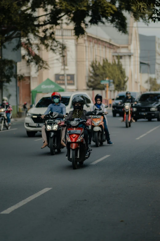 motorcyclists ride along the road in traffic
