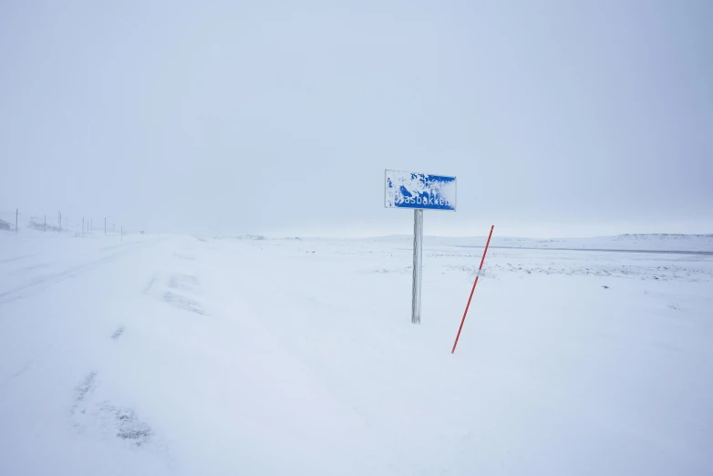 a snowy field with a sign out front