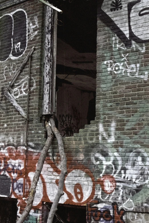 this is a brick building with graffiti and a broken window