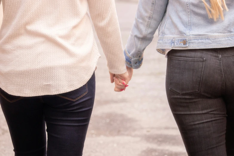 two people holding hands walking on the street