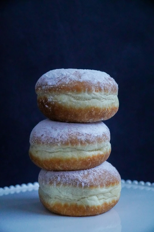 three powdered donuts stacked on top of each other