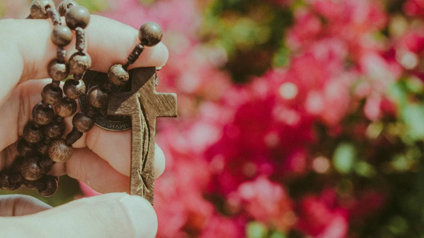 a person holding a rosary and a rosary