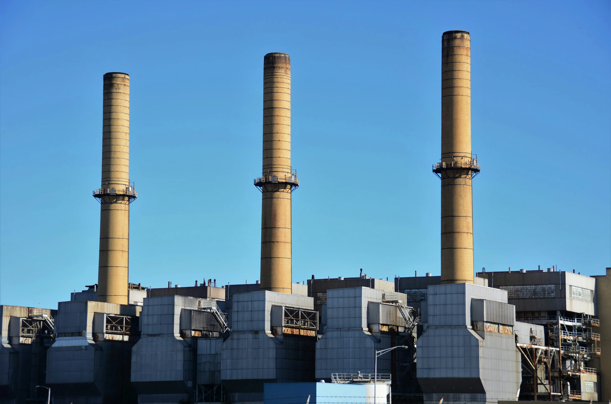 three smoke stacks sitting outside of an industrial building