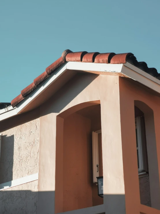 roof and corner of a brown stucco house