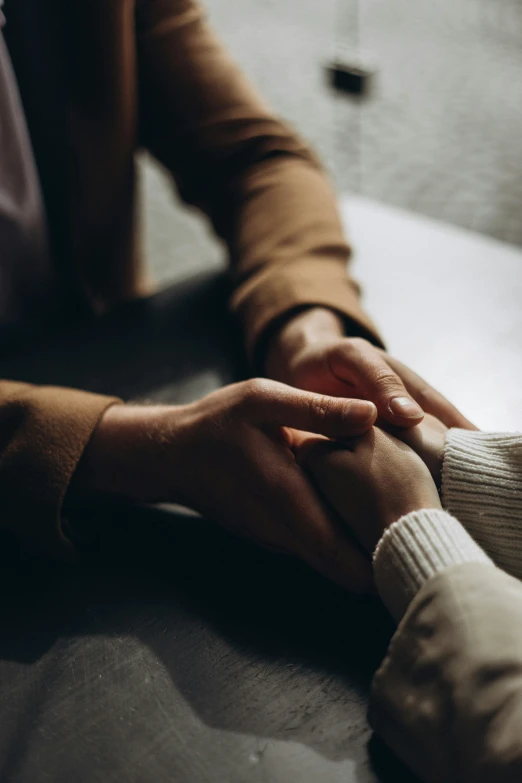 close up of a couple holding hands sitting next to each other