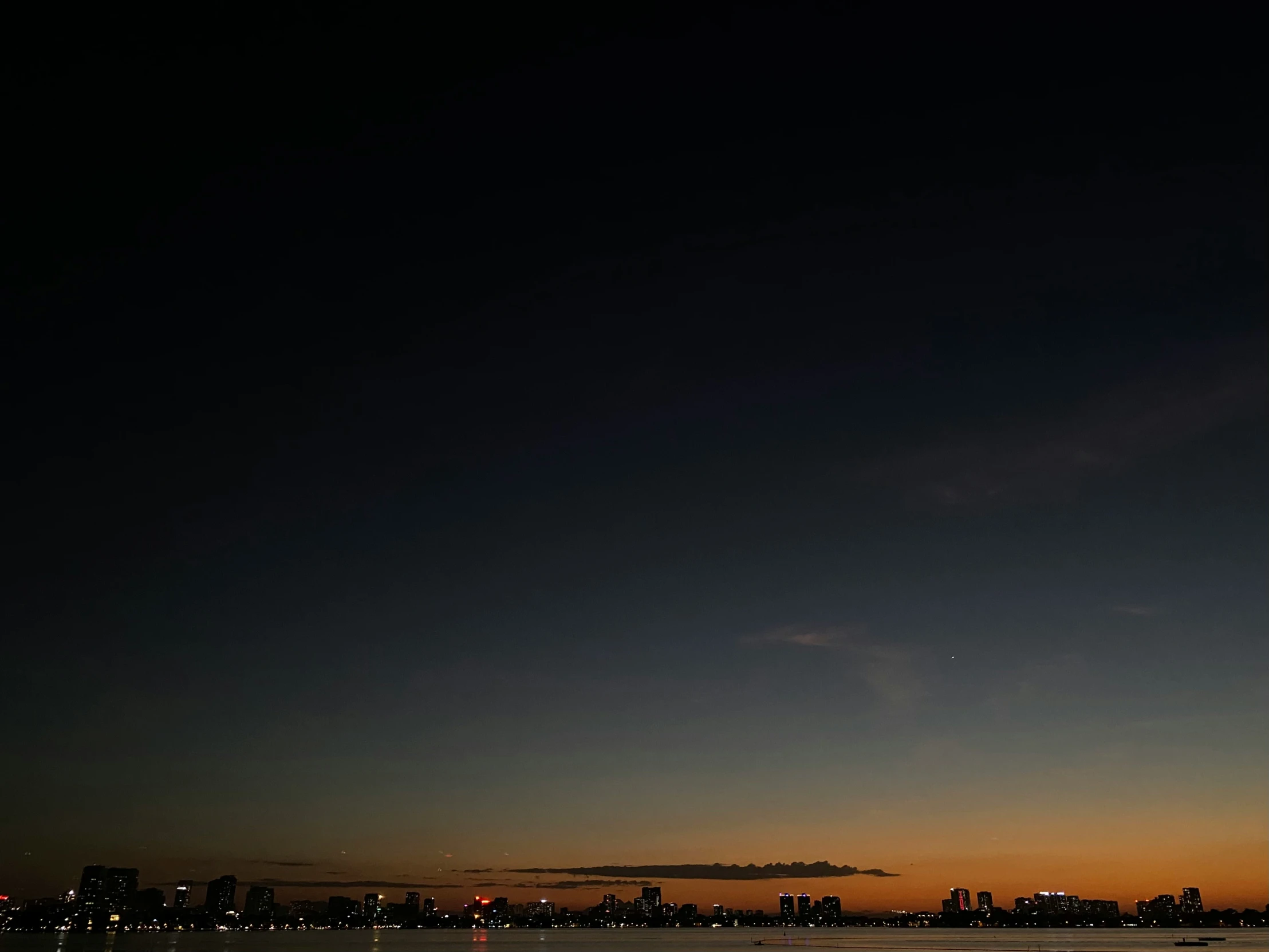 the skyline is silhouetted against the dark background