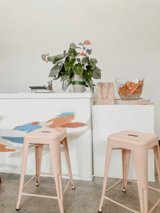 three stools in front of a counter that has flowers on it