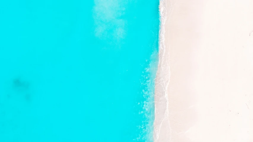 top down view of two people walking on the sand near the beach