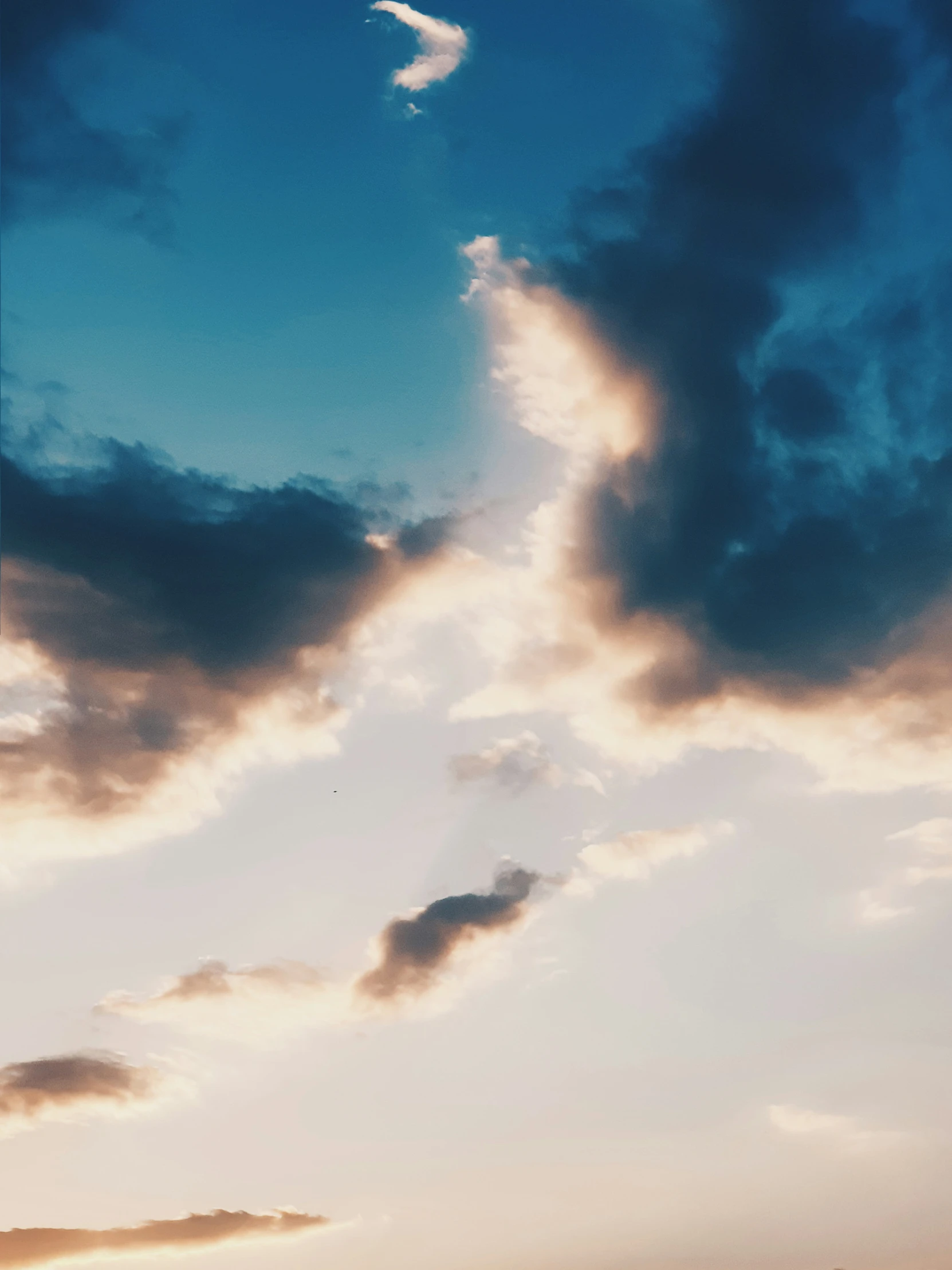 an airplane flying into the cloudy blue sky