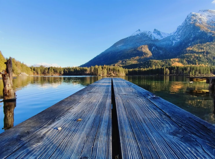 a wooden dock on a lake near mountains