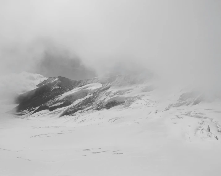 a black and white image of snow covered mountains