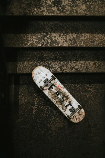 the abandoned skateboard is on the ground outside