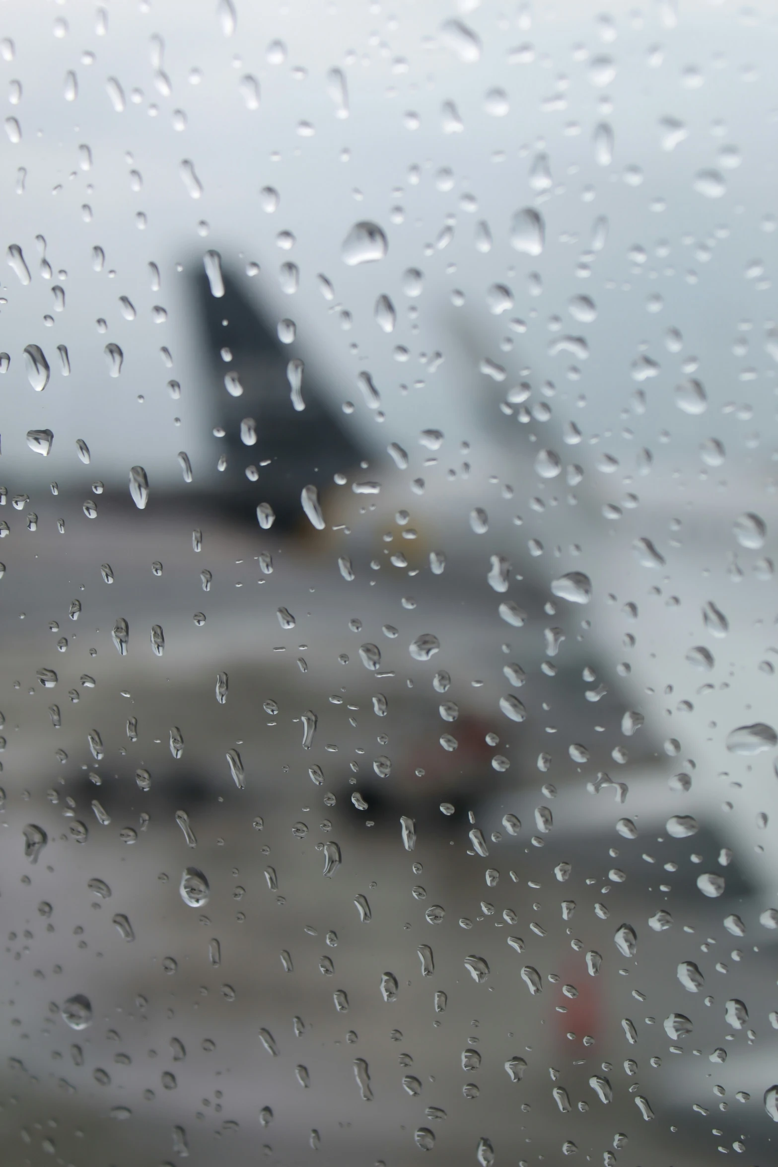 rain is falling down on a plane with airplanes in the background