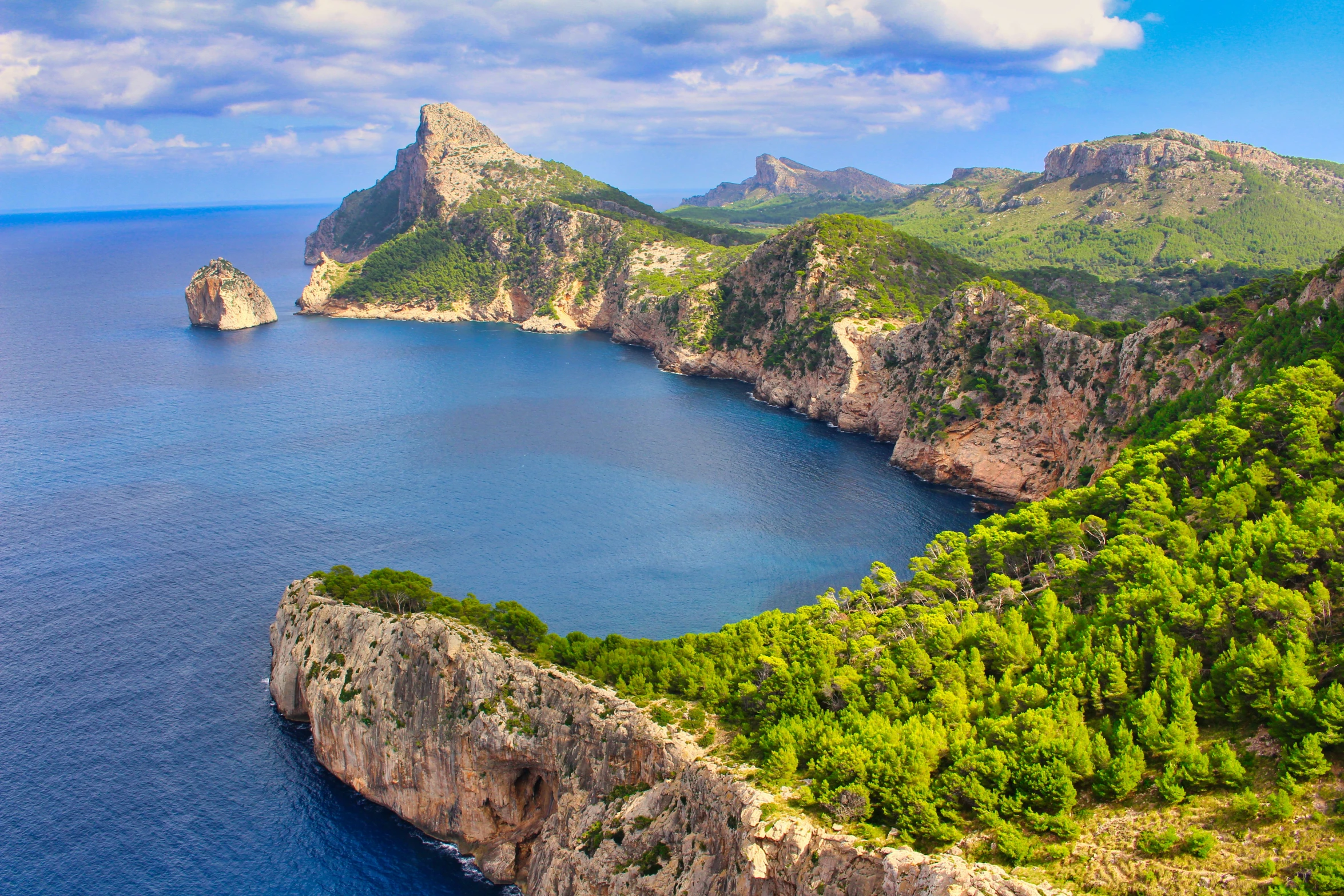 an aerial view of a blue sea surrounded by mountains