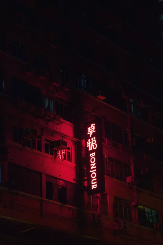 a red neon sign outside of a tall building