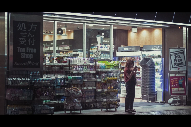 a woman standing outside of a store with an umbrella