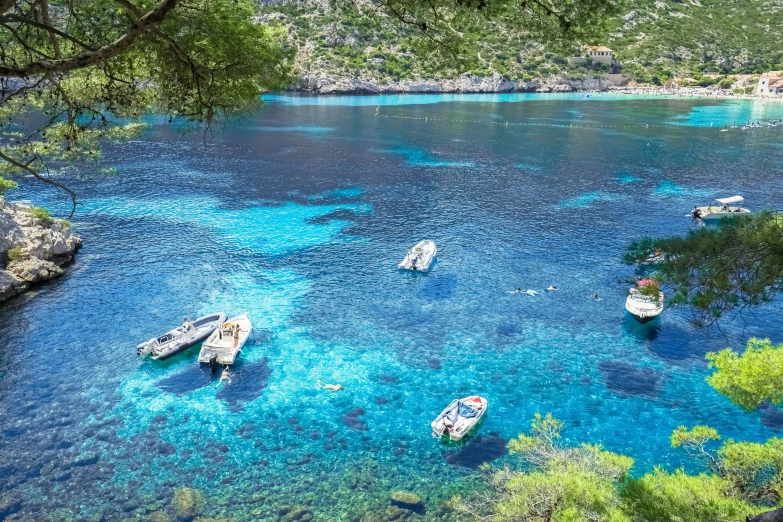 a group of boats are floating in a blue lagoon