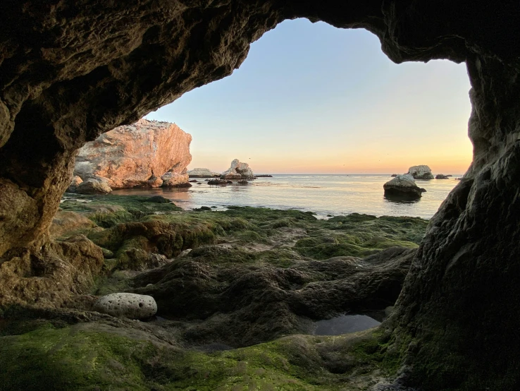 the ocean view through a cave on the shore