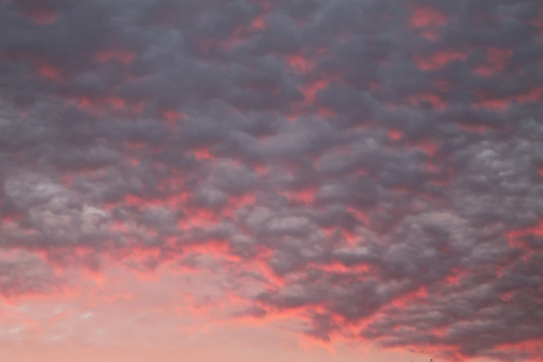 an airplane flies high in the sky during sunset