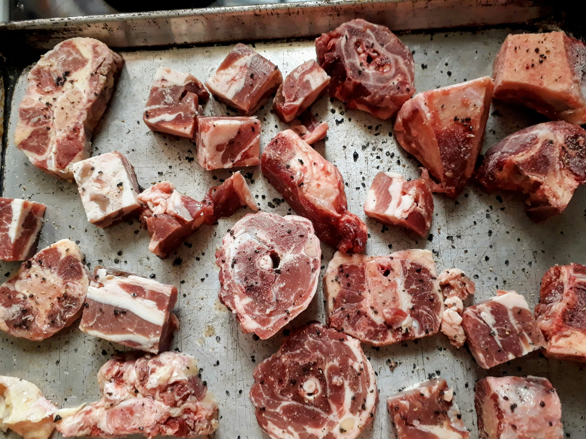 raw meat is shown on a pan with seasoning