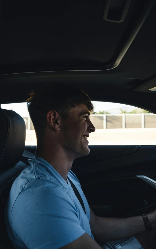 a man smiles in the back seat of his car