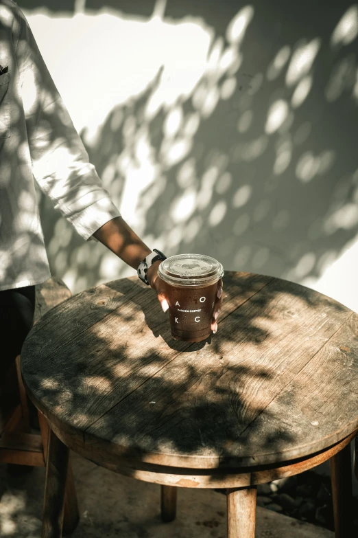 the person is holding onto a jar on a table