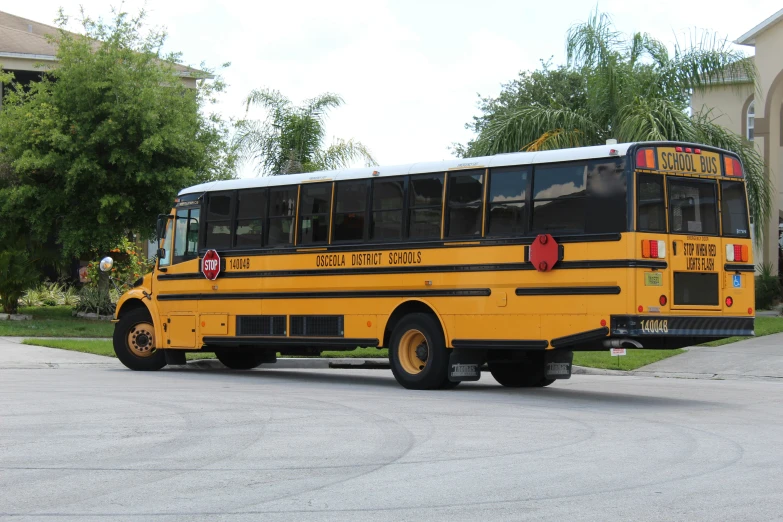 a yellow school bus parked next to a driveway