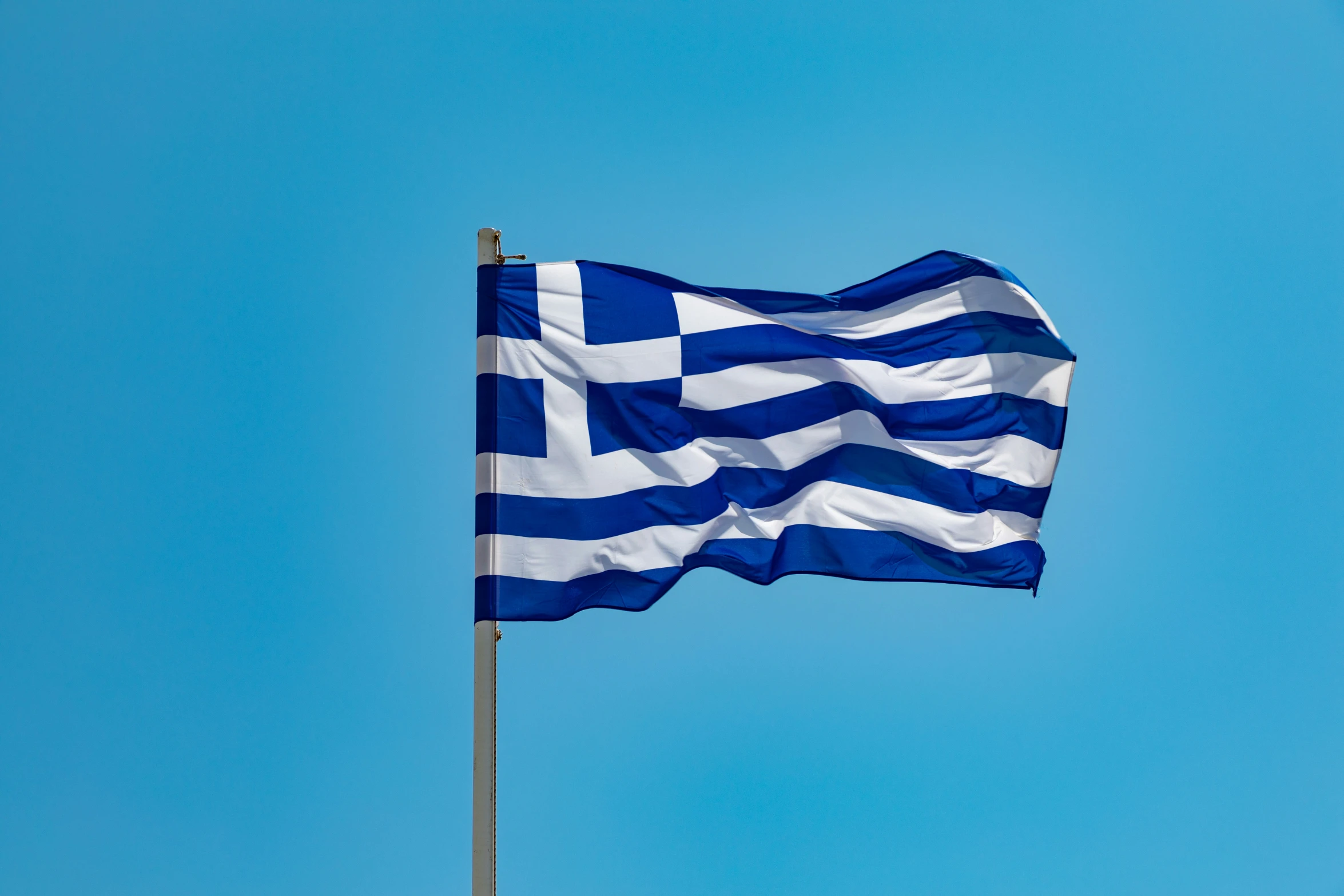 a close up view of a flag with a blue sky behind it