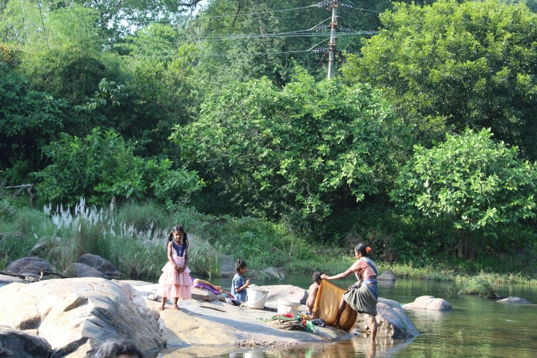 people playing in the water of a stream