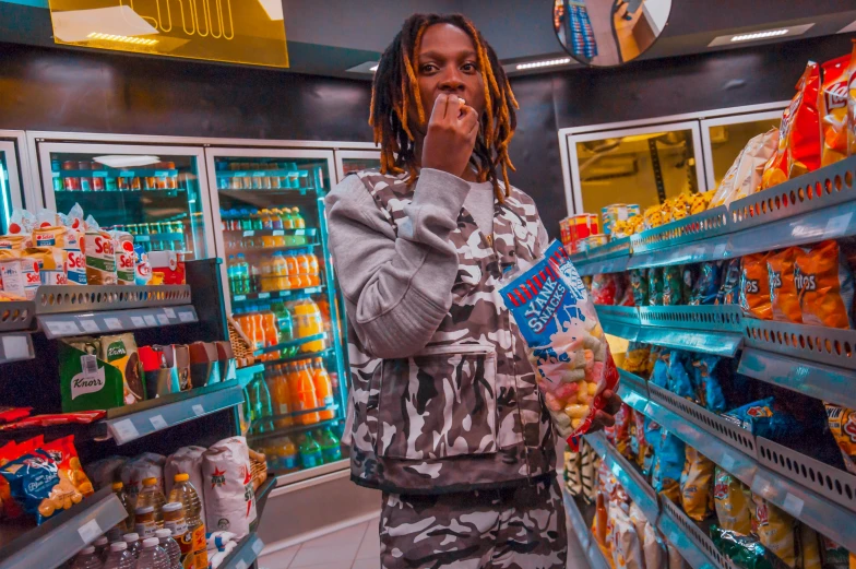 a young man in the supermarket is drinking out of his mouth