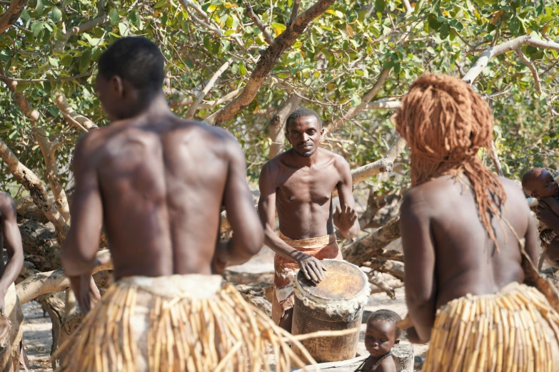 a group of african men standing in a jungle