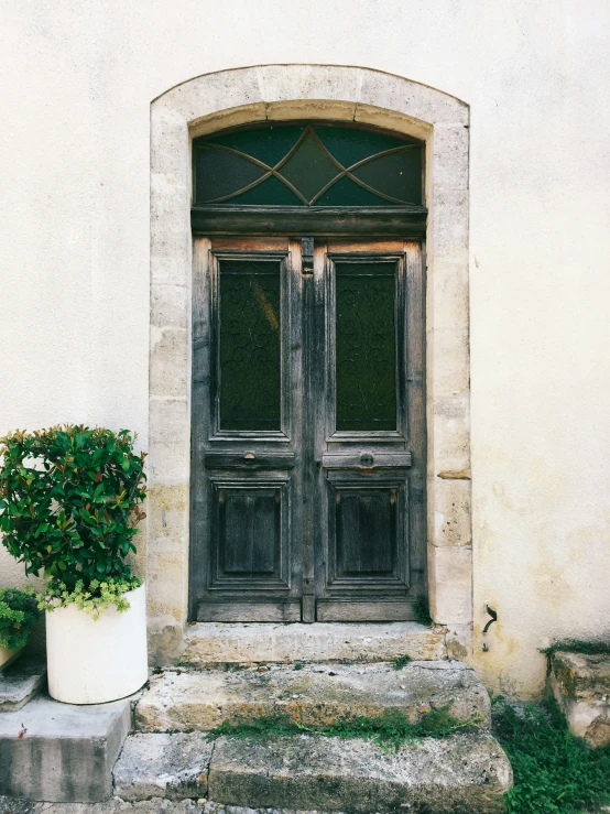 an old building has a flower pot with two pots on the outside