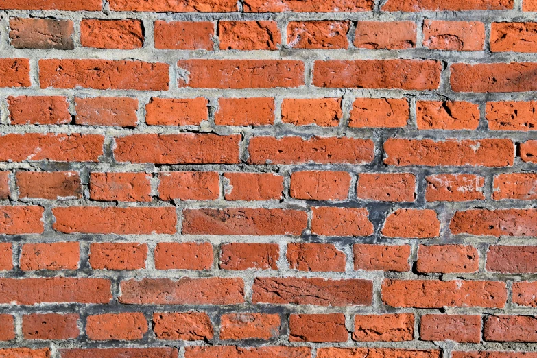 an orange brick wall with light colored stains