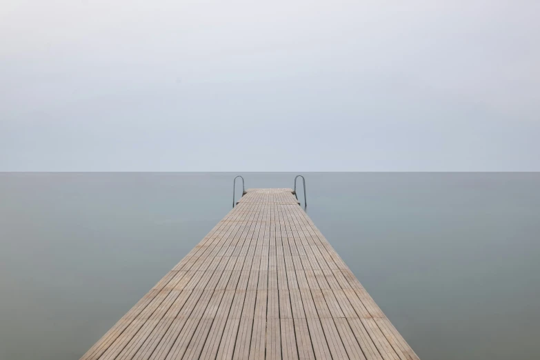long pier leading out into the ocean on a foggy day