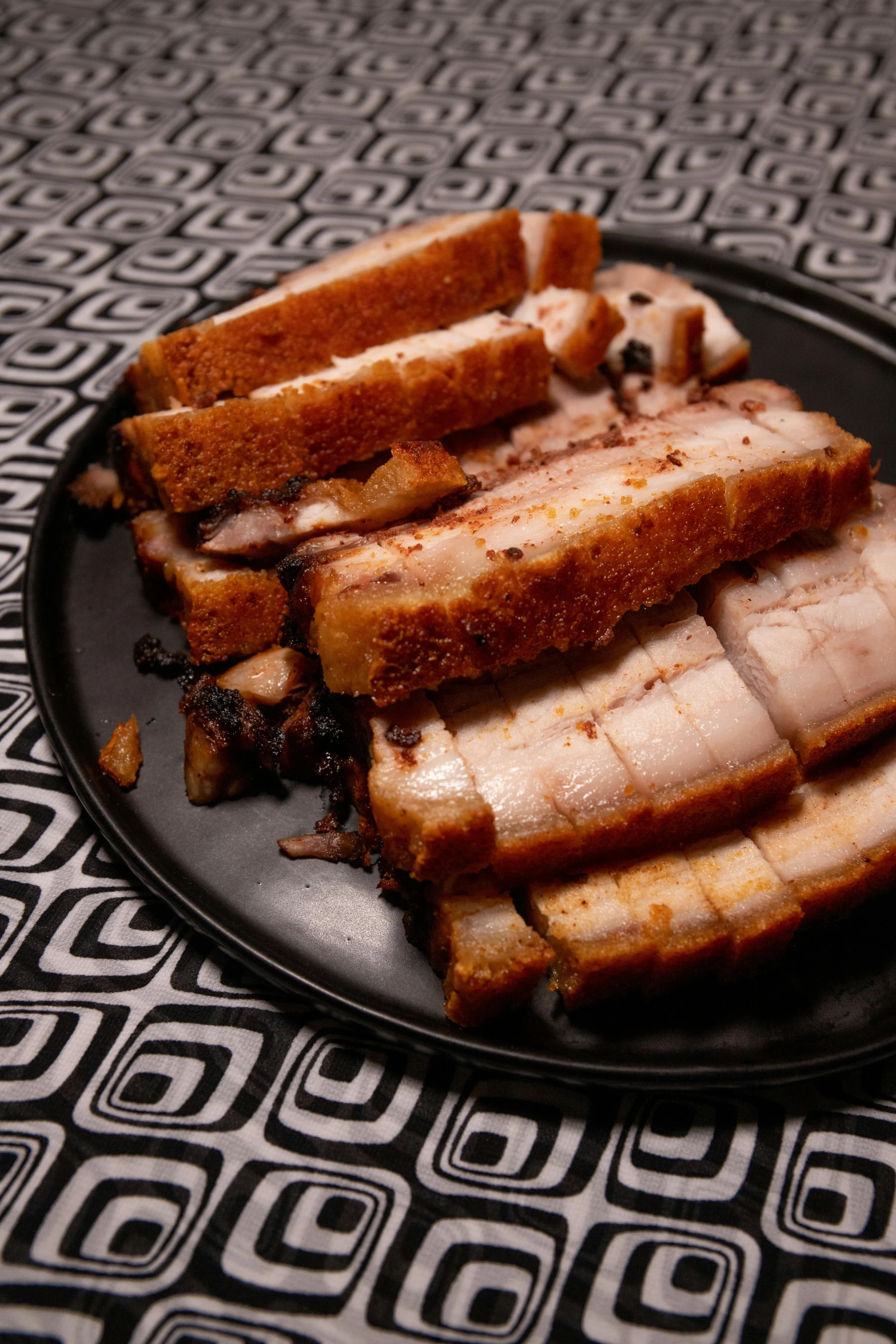 slices of meat sitting on top of a black plate