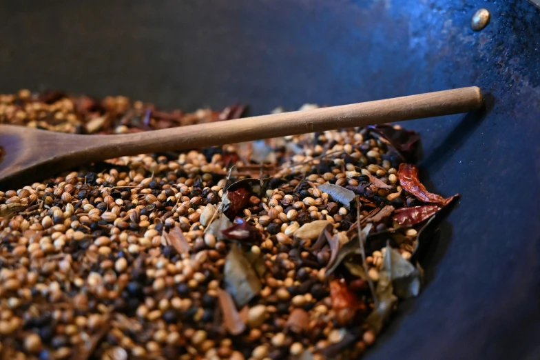 a pan filled with a wooden spoon and some food