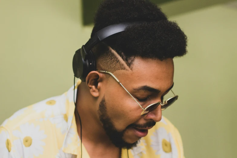 a young man wearing glasses is listening to the music