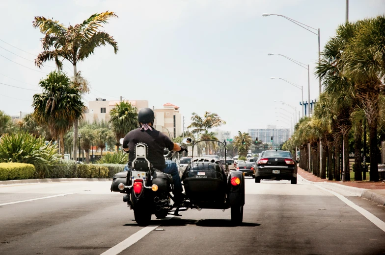 a man on a motorcycle passing a car on the highway