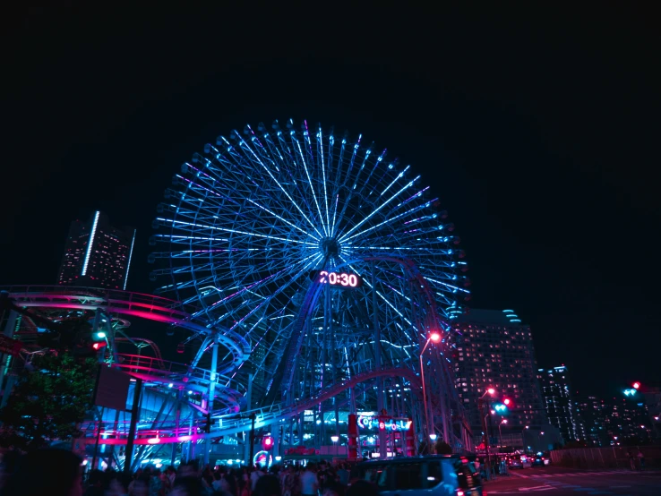 a large lighted wheel next to a city skyline