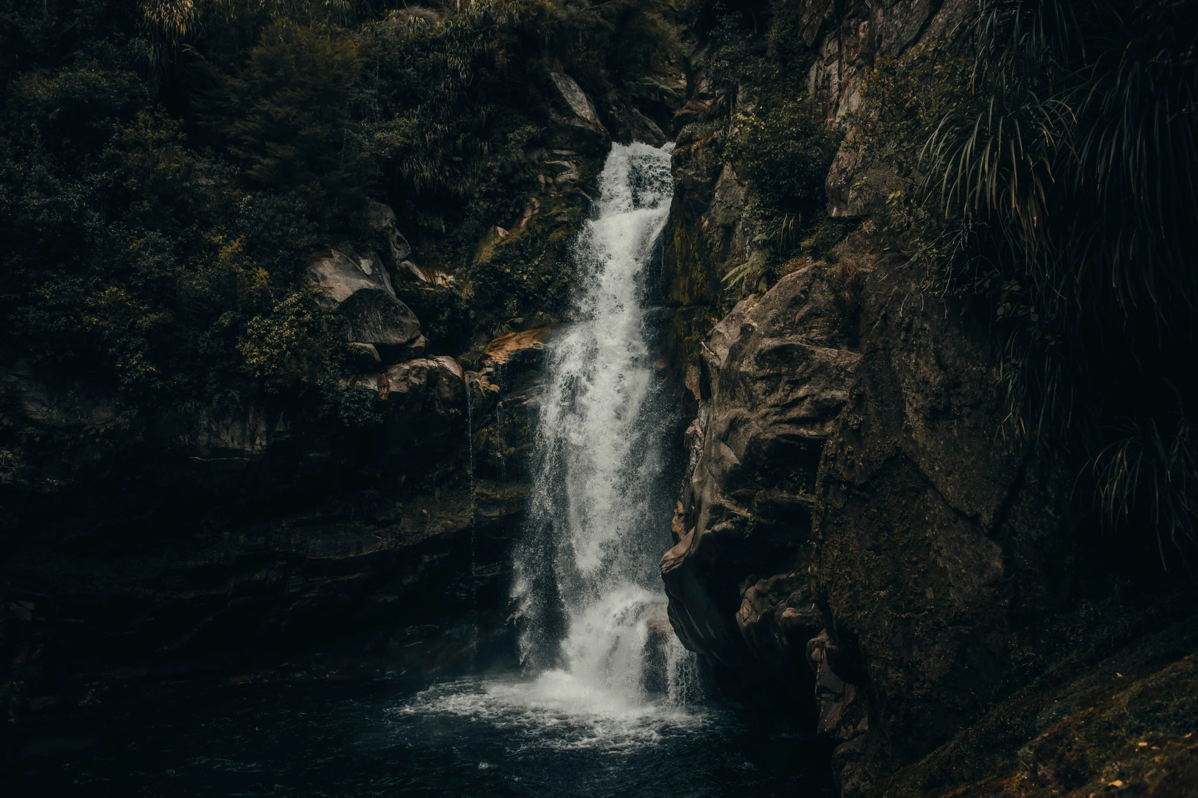 there is a small waterfall flowing over the side of a cliff