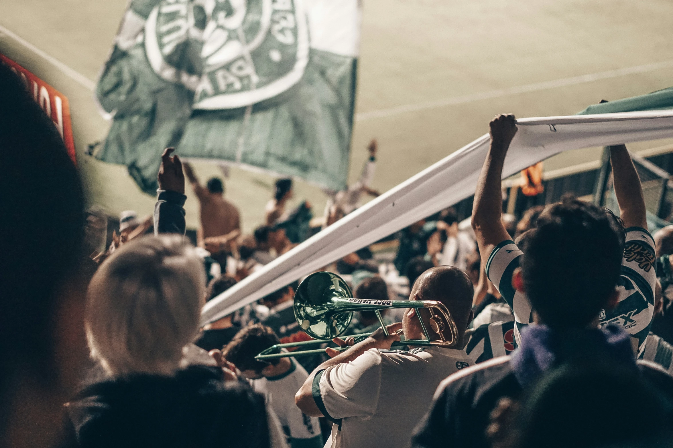 a group of people standing in front of a green and white flag