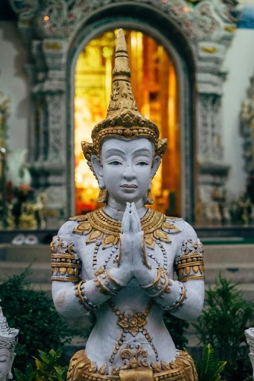 a statue of a person sitting in front of a building