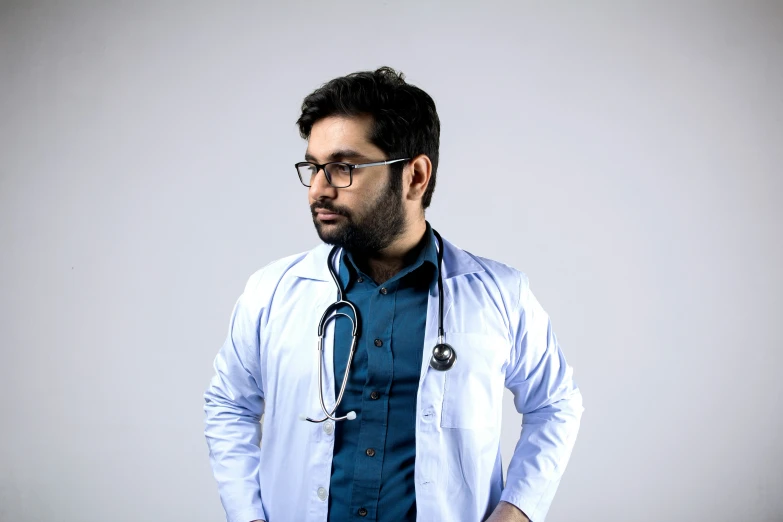 a man wearing glasses and a stethoscope standing up