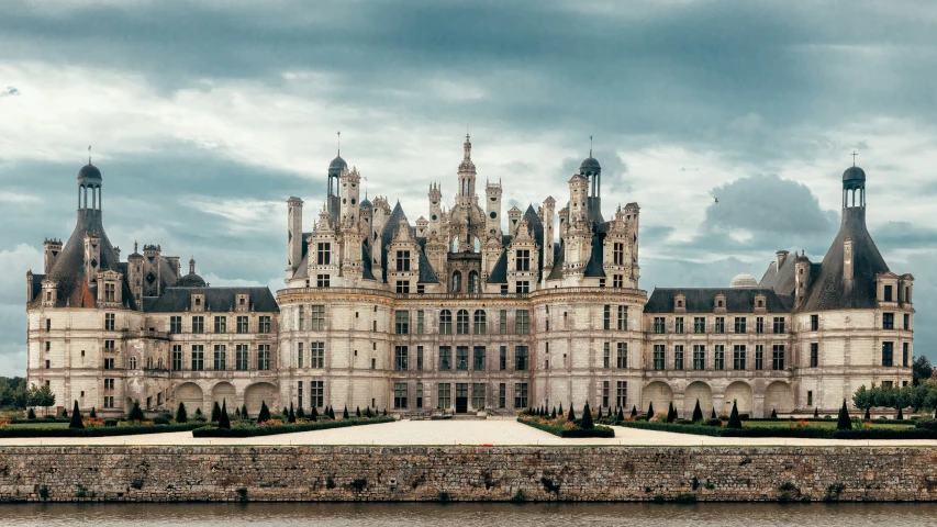 an ornate castle sits over water in the middle of a park