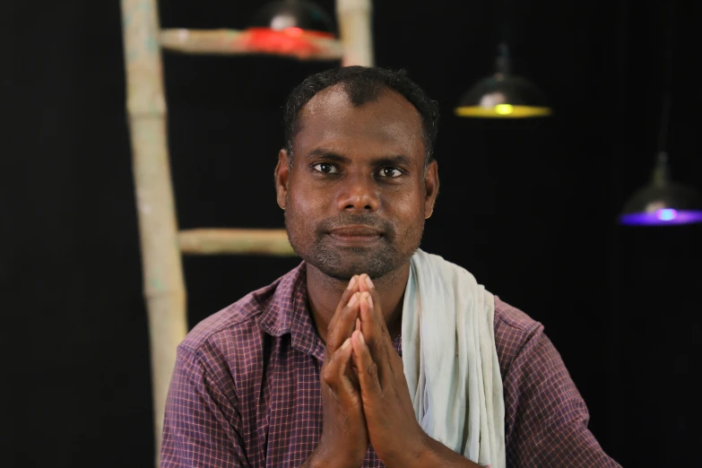 a man holding his hands together and meditating