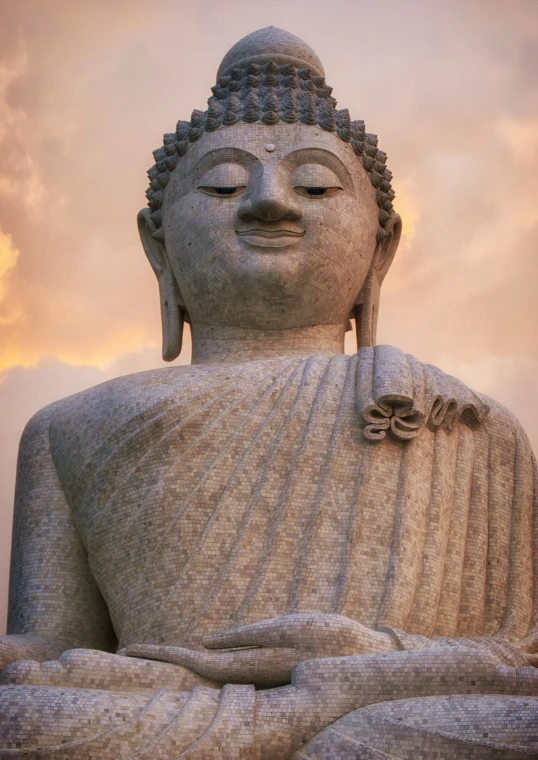 the big buddha statue is next to a building