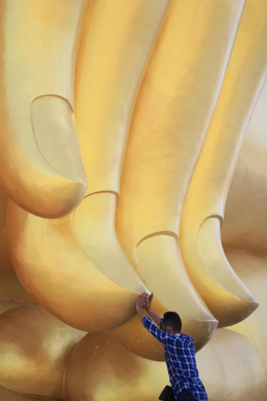 a man standing next to bananas shaped like the back of a giant banana