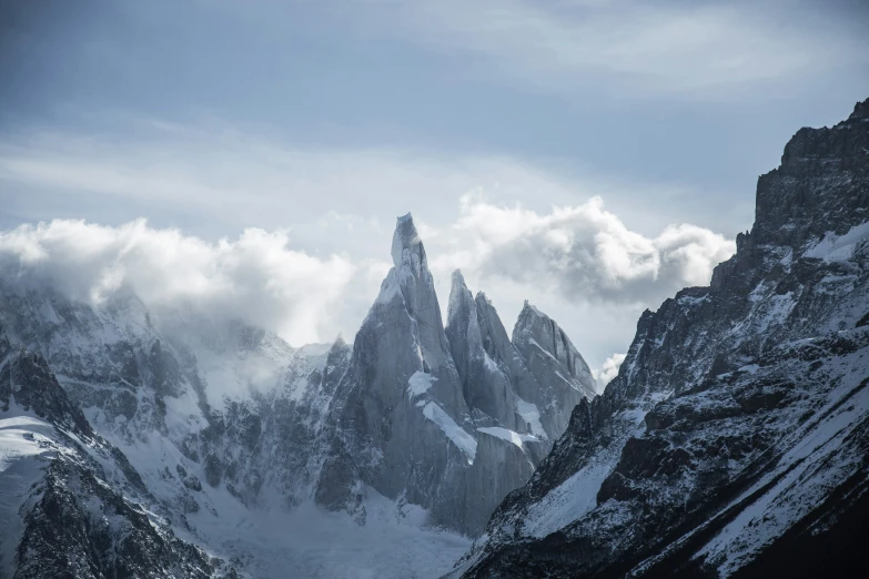 the mountains are covered in clouds on a snowy day