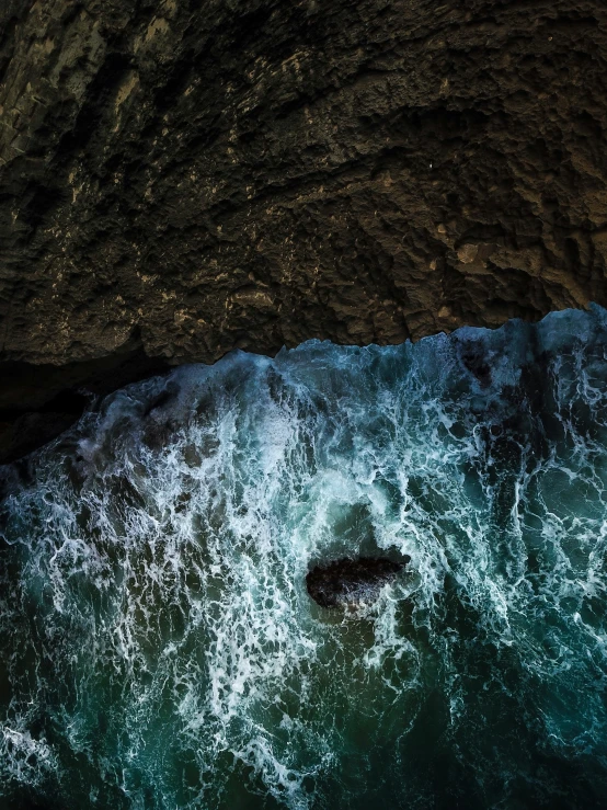 a blue and black body of water surrounded by rocky shoreline