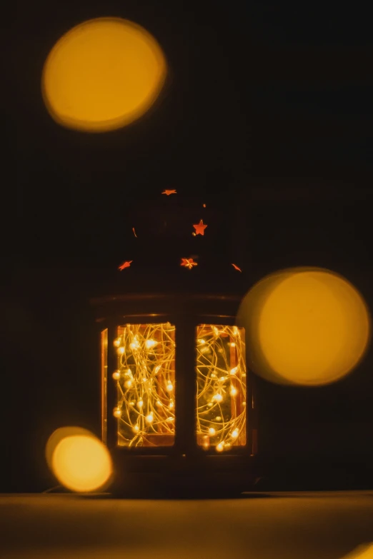 two small lighted lanterns that are lit in the dark